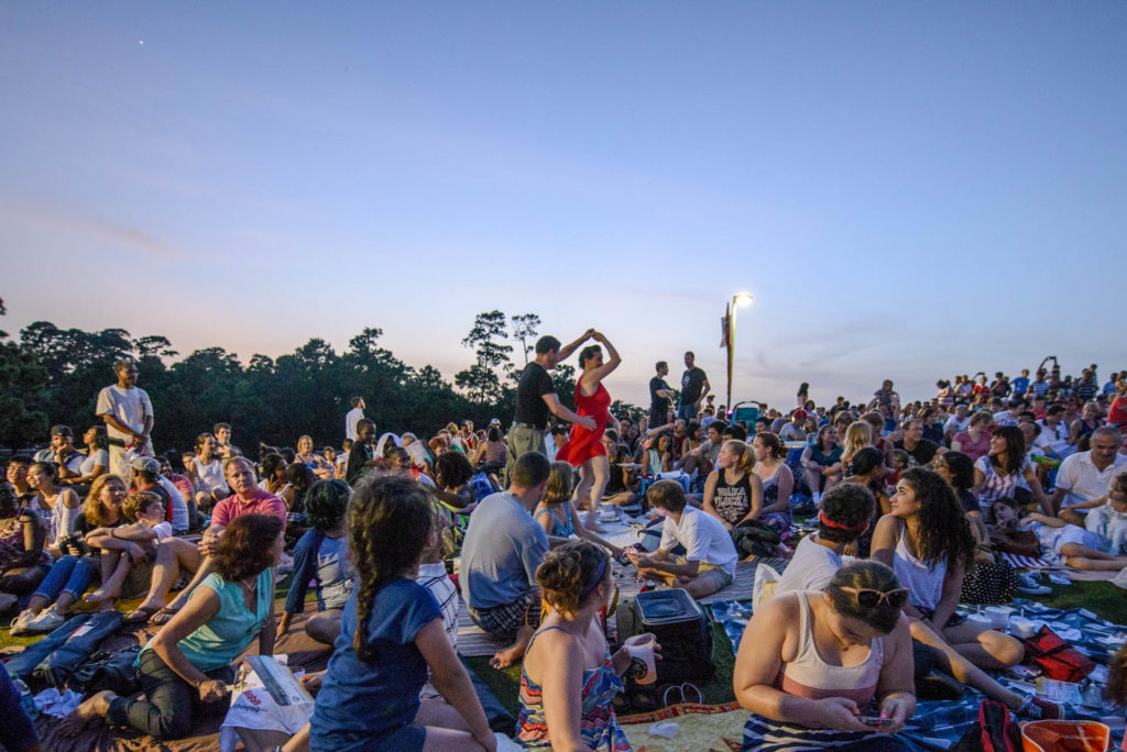 A couple dances in the audience at Miller Outdoor Theatre